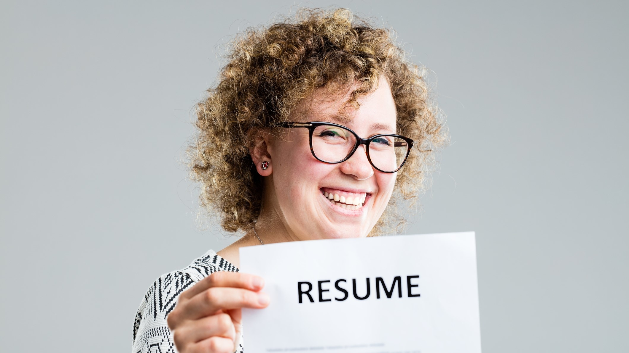 happy woman holding up her reume or cv 