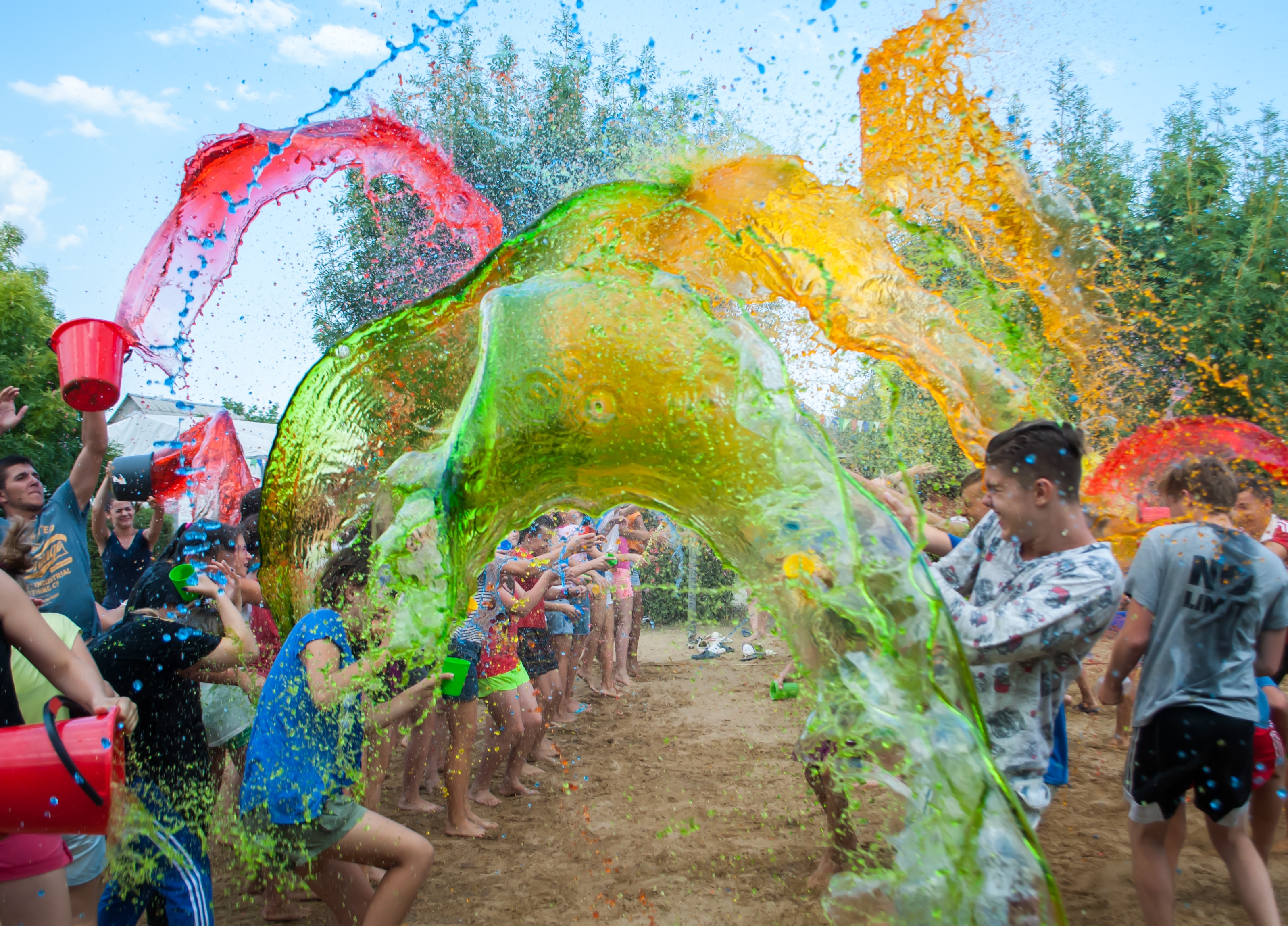 group of camp friends having a paint fight as part of one of the hottest summer jobs as a camp counselor