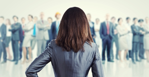 Business professional facing a crowd of of other professionals feeling prepared to answer interview questions